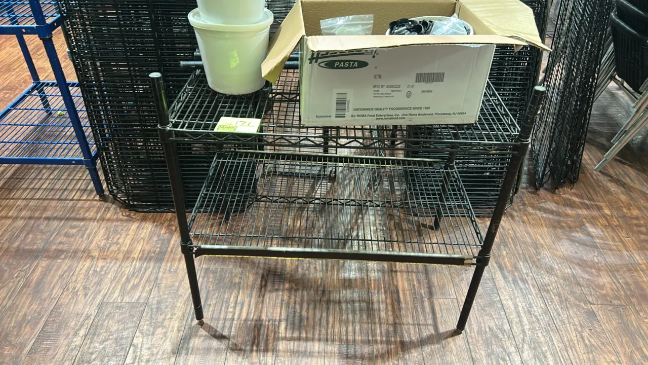 Metro 2-tier wire shelving rack. Features black wire construction, (2) wire shelves, extra posts, and containers of shelf clips/clamps. Dimensions: 36