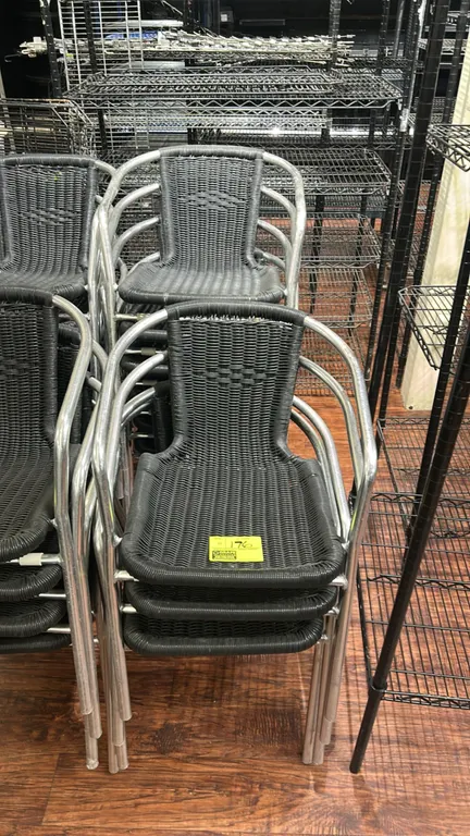 Outdoor stacking armchairs. Features woven synthetic wicker seats and backrests, tubular metal frames, and integrated armrests.