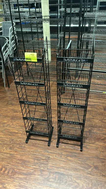 The Republic of Tea metal wire multi-tier display merchandisers. Features 5-tier slanted wire basket shelving with 'The Republic of Tea' branded shelf