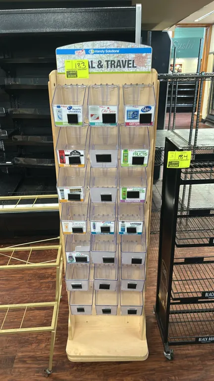 Handy Solutions 2-sided rotating merchandiser display. Features light woodgrain laminate construction, (21) clear plastic merchandising bins with labe