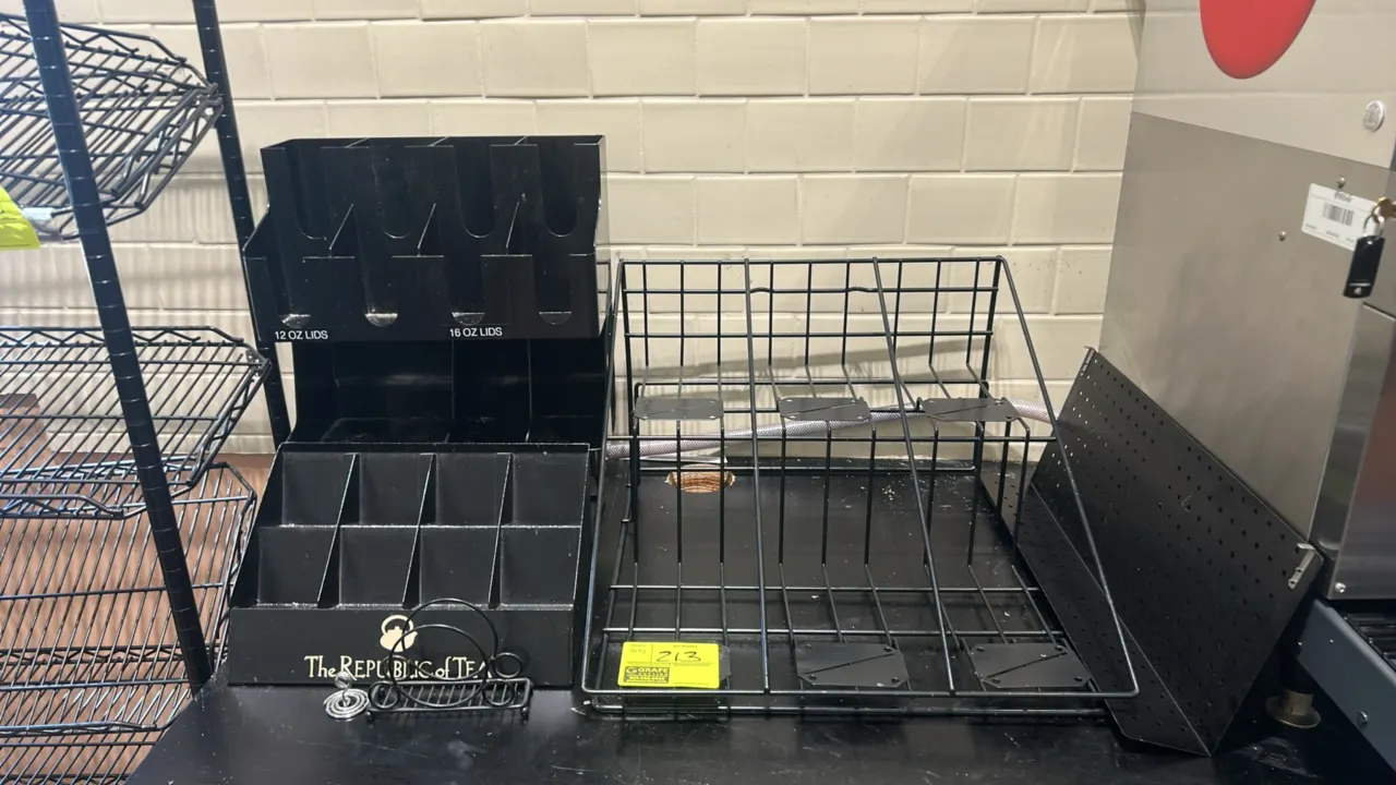 Assorted countertop display racks and organizers. Includes tiered wire display rack, multi-compartment acrylic cup and lid organizer, 'The Republic of