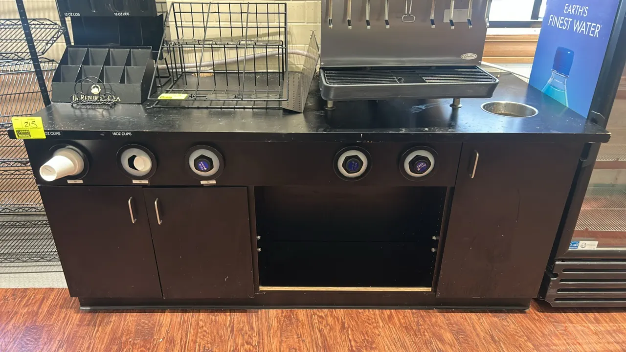 Laminate drink service counter. Features black laminate construction, (5) built-in cup dispensers, stainless steel trash chute drop-in grommet, double