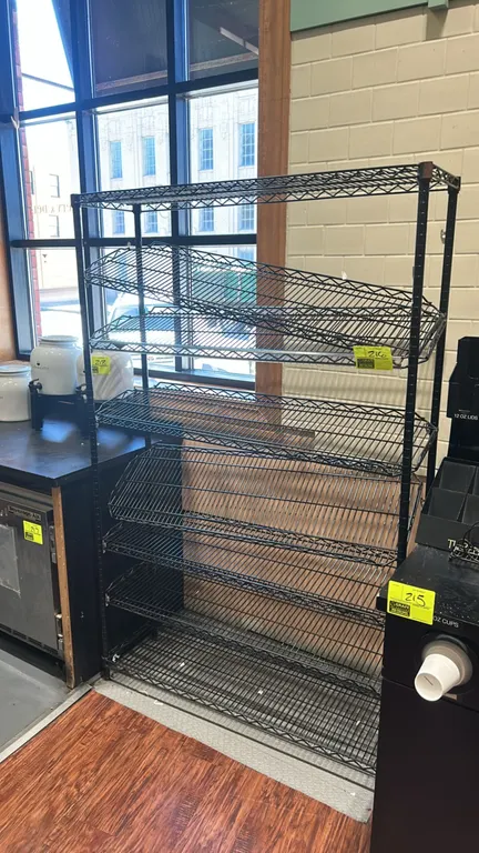 Metro multi-tier wire shelving rack. Features black finish with flat and slanted display shelves. Dimensions: 48" x 14".