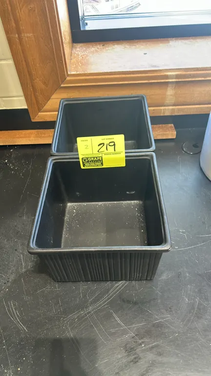 Black plastic dressing containers. Features ribbed exterior and square design. 9".