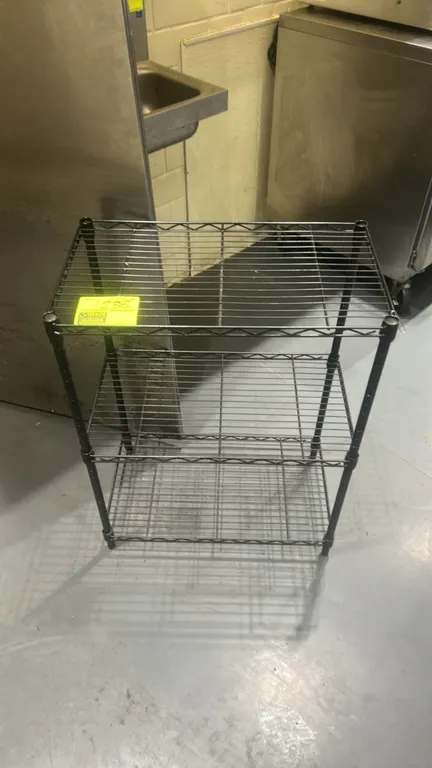 3-tier metal wire shelving rack. Features (3) adjustable wire shelves and black finish. Dimensions: 23" x 13". Mounted on adjustable leveling feet.