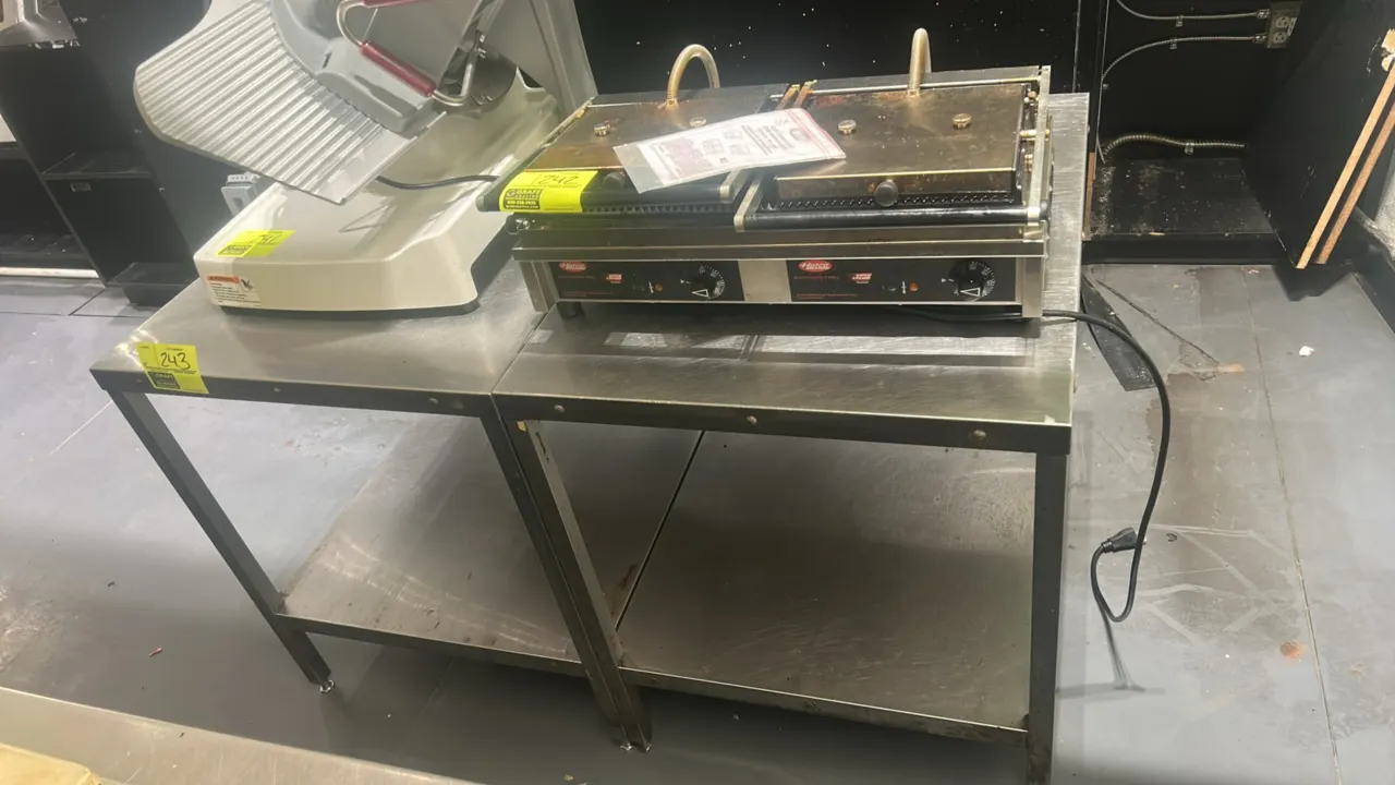 Stainless steel work table. Features a lower undershelf and square legs with adjustable bullet feet. 54" x 32". Contents not included.