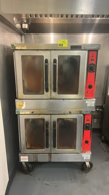 Vulcan VC55GD double-stack natural gas convection oven. Features stainless steel construction, glass-window doors, interior wire racks, and analog tem