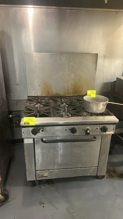 Southbend 6-burner gas range with integrated oven. Features cast iron grates, stainless steel high backsplash, and interior oven rack. Mounted on cast