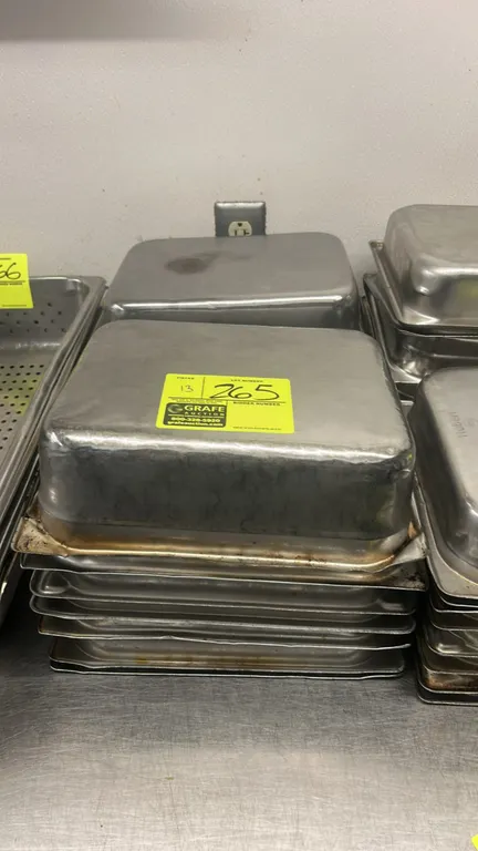 Stainless steel half-size insert pans. Features durable metal construction suitable for steam tables or food prep. Dimensions: 4" depth.