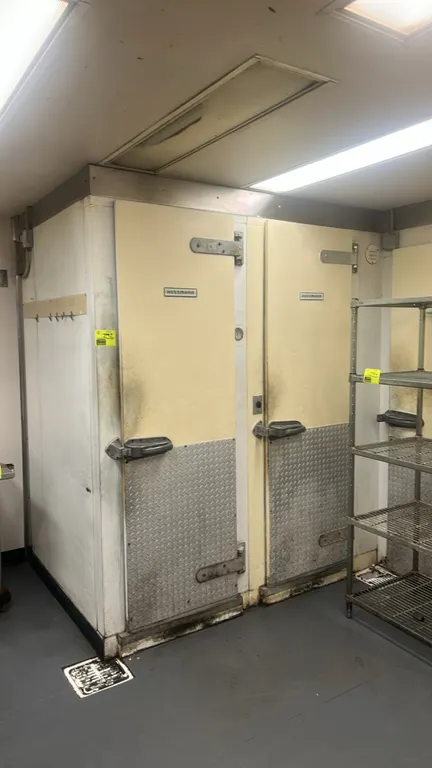 Hussmann foam panel walk-in freezer. Features (2) hinged access doors with diamond plate kick plates, (1) 1-fan evaporator, (1) 2-fan evaporator, and