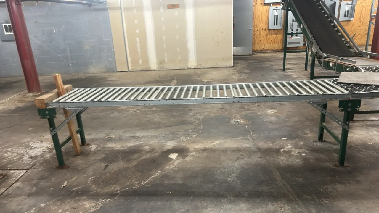 Metal conveyor system. Includes incline belt conveyor, curved skate wheel section, and straight gravity roller conveyor sections. 44'L. Mounted on adj