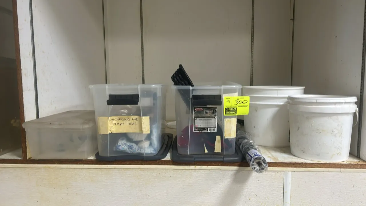 Assorted catering and packaging supplies. Includes plastic banquet table cover roll, black wicker baskets, clipboard, plastic storage totes with lids,