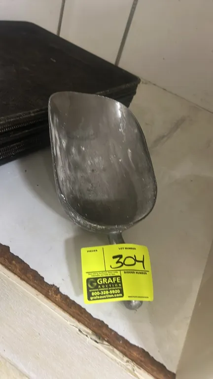Metal ice scoop. Features cast metal construction with an integrated handle.