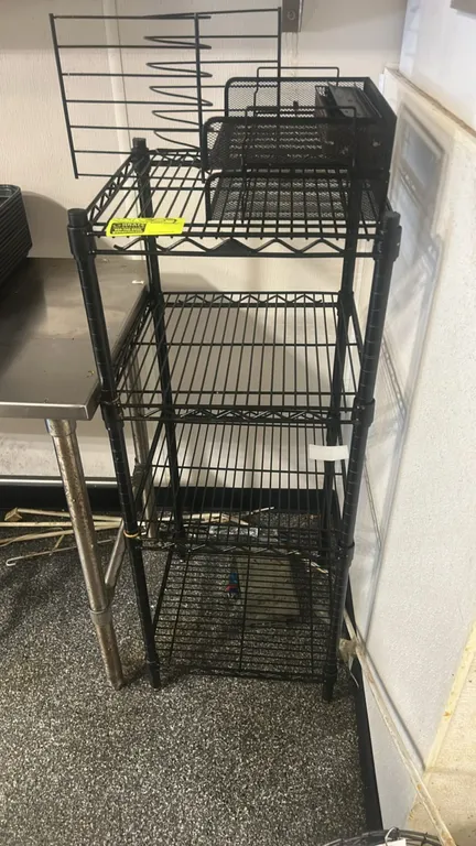 Metal wire multi-tier shelving rack with metal organizers. Features 4 wire shelves with a black finish. Includes assorted metal wire and mesh desk org