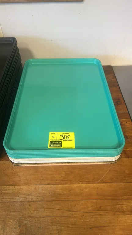 Full-size poly trays. Features assorted colors including teal, white, and tan, and a stackable design.