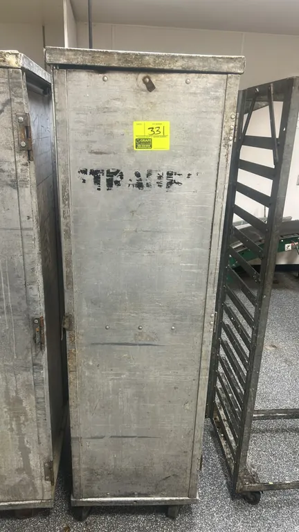 Aluminum sheet pan transport cabinet. Features a single hinged door and interior pan slide runners. Mounted on casters. Adjacent equipment not include