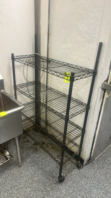 Metal wire multi-tier portable rack. Features (4) adjustable wire shelves in a black finish. 36" x 14". Mounted on casters. Note: Front and rear uprig