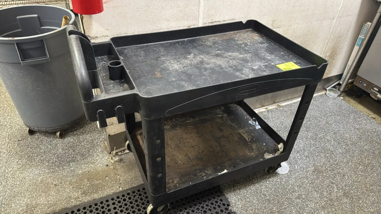 Rubbermaid BRUTE 2-tier poly utility cart. Features molded push handle with integrated storage compartments. 36" x 24". Mounted on casters.