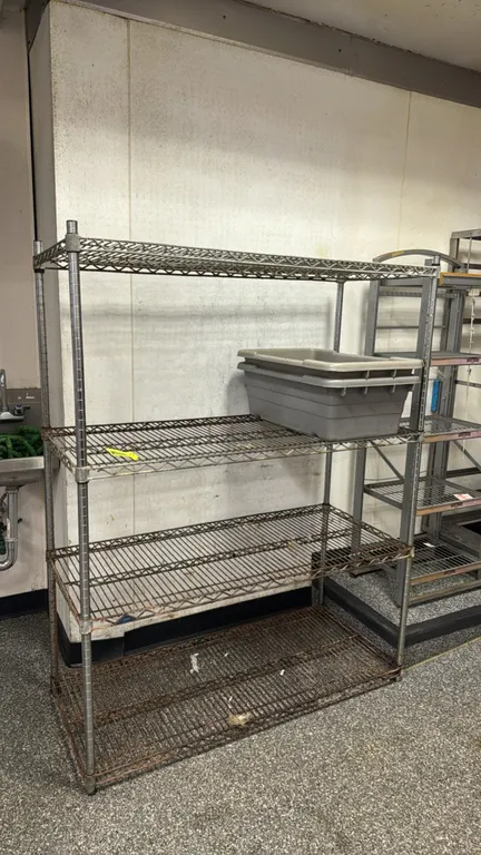 Metal 4-tier wire shelving rack. Features (4) adjustable wire shelves. Dimensions: 48"W x 18"D x 62"H. Note: Shelves exhibit heavy rust and corrosion.