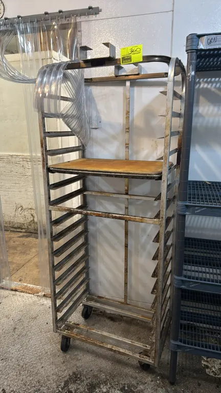 Aluminum side-load roll-in oven rack. Features multi-tier pan slides, top lift brackets, and tubular frame construction. Mounted on swivel casters. Sh
