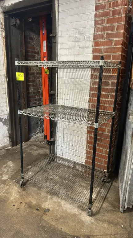 Metal 3-tier portable wire shelving rack. Features (3) wire shelves and black upright posts. 36" x 24" x 58". Mounted on casters.