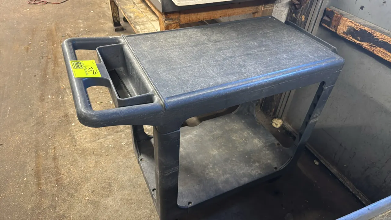 2-tier polyethylene utility cart. Features molded plastic construction, an integrated push handle with built-in storage compartment, and two tiers. 30