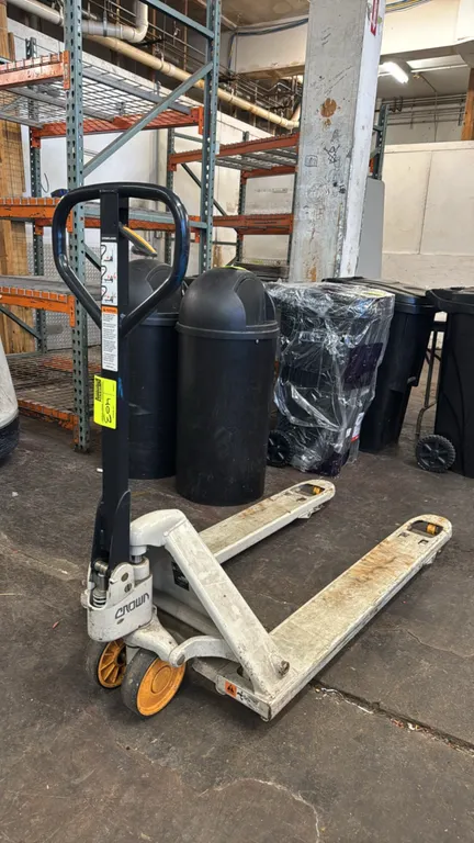 Crown PTH 50 manual hydraulic pallet jack. Features loop handle with fingertip release lever, 5,000 lb load capacity, polyurethane steer wheels, and s