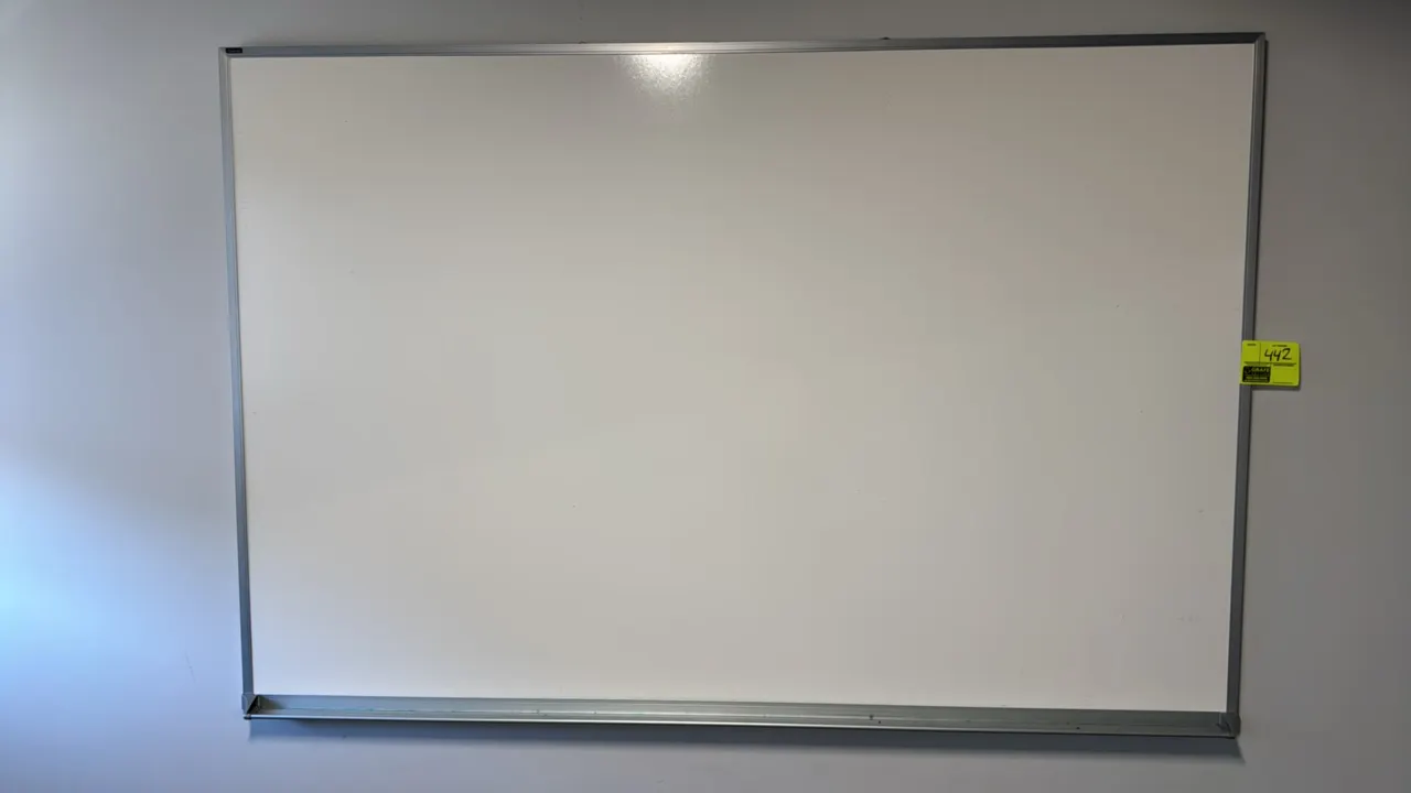 Dry erase board. Features an aluminum frame and integrated marker tray. 6' x 4'. Wall mounted.