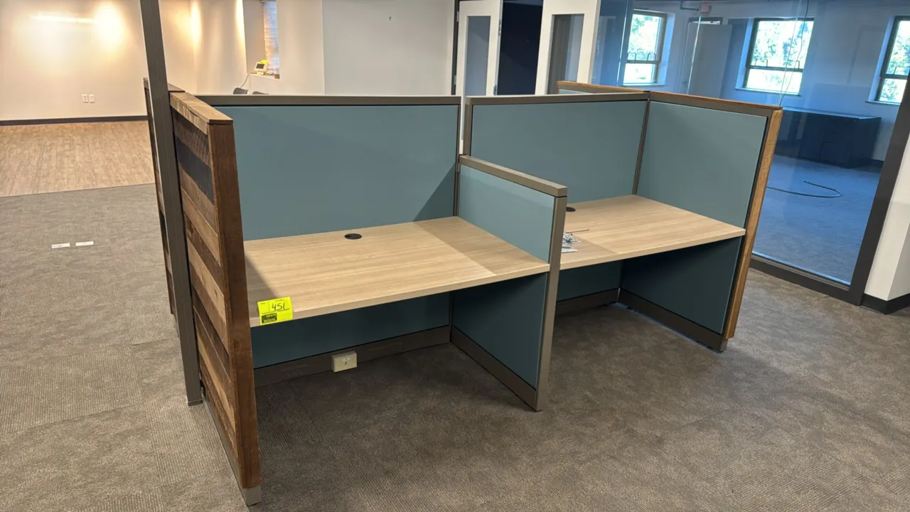 4-cubicle workspace system. Features woodgrain laminate desktop surfaces with cable grommets, blue fabric divider panels, rustic wood plank end panels