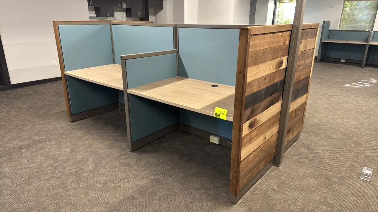 4-cubicle workstation pod. Features back-to-back desks with woodgrain laminate work surfaces, teal fabric privacy panels, rustic wood plank end panels
