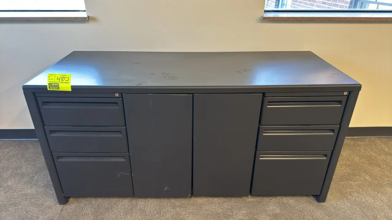 Metal credenza with fabric corkboard. Credenza features a laminate top, two 3-drawer pedestals, and a center 2-door cabinet with an interior shelf. Di