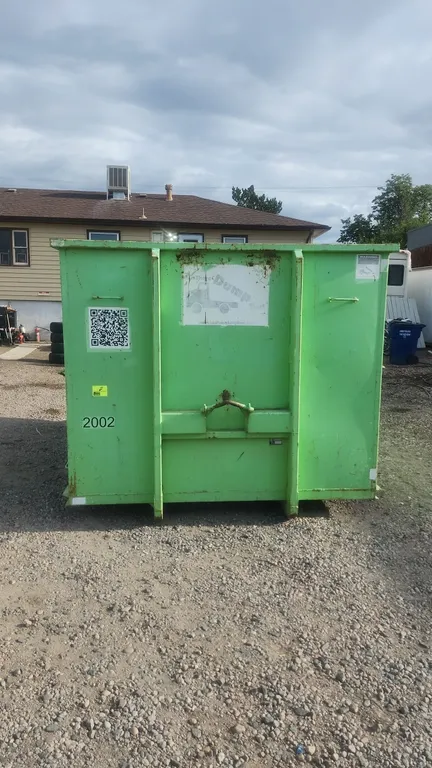 20-yard hooklift dumpster container. Features rear swing barn doors, front hooklift bar with 36" hook height, and rear roller. Marked container #2002.