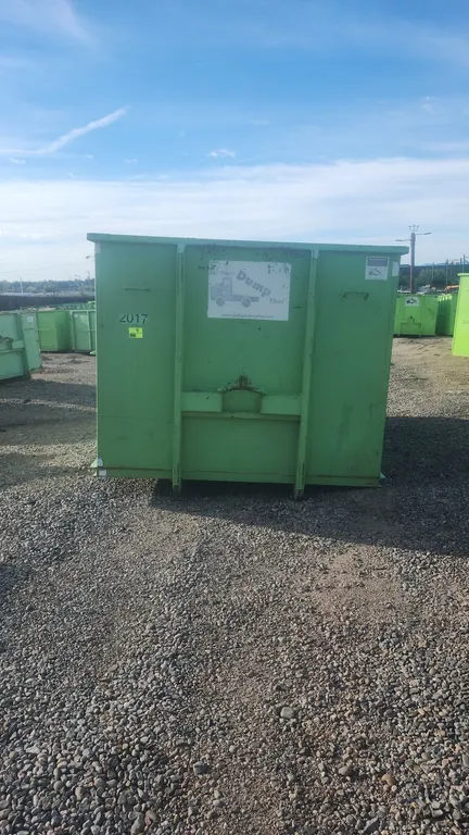 20-yard hooklift dumpster container. Features rear double barn doors with locking latch mechanism, side wood plank pockets, and bottom ground roller.