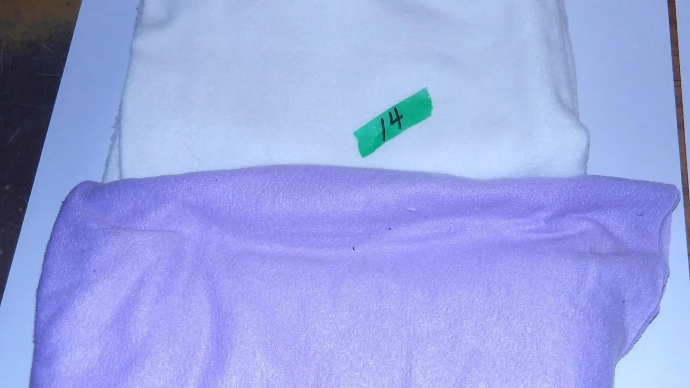 UNCLAIMED STORAGE: PURPLE FLEECE (APPROX. 60" X 30") & WHITE FLEECE (APPROX. 60" X 30")