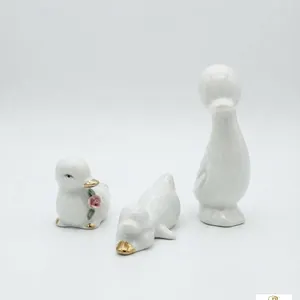 Three Ceramic Duck Figurines with Gold Accents