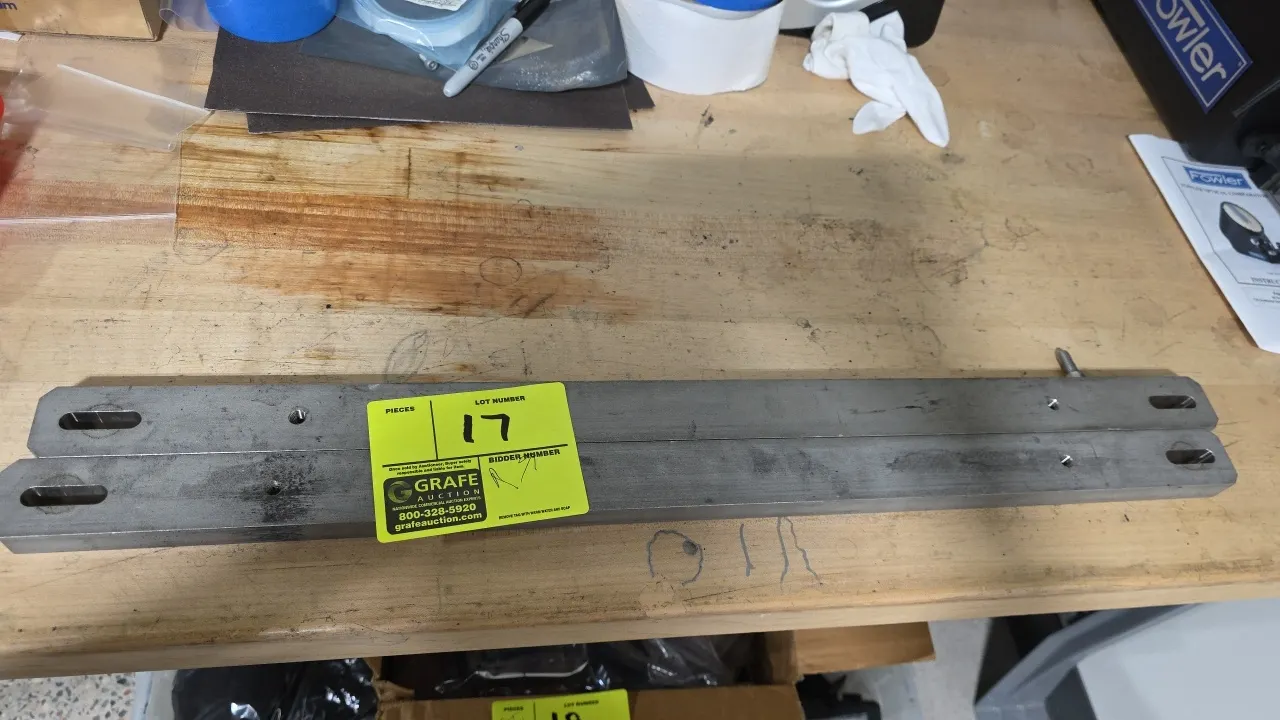 Machined metal bars. Lot of (2). Features slotted mounting holes and threaded holes. Dimensions: 26-1/4" x 1-1/2" x 3/4" each.