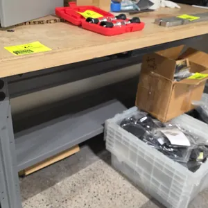 Wood top workbench. Features a wood work surface, gray metal frame, and lower metal undershelf. 72" x 30". Contents not included.