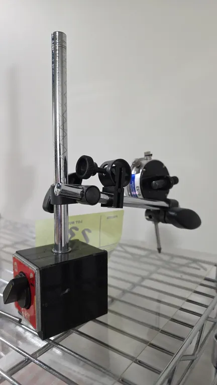 Eclipse magnetic base stand with dial indicator. Features a switchable on/off magnetic base, upright post, cross arm with fine-adjustment clamp, and a