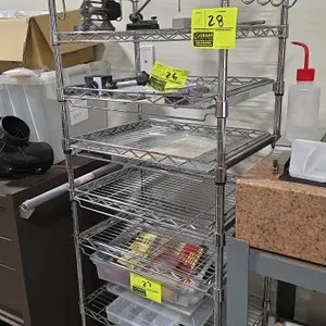 Chrome 8-tier portable wire shelving cart. Features (4) slide-out shelves, fixed wire shelves, and hanging hooks. 21" x 15" x 61.5". Mounted on caster