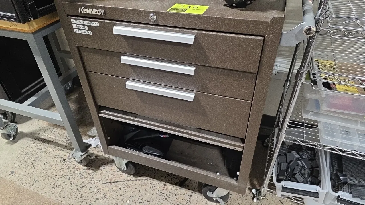 Kennedy metal 3-drawer portable tool cabinet. Features brown wrinkle finish, 3 pull-out drawers, bottom storage compartment with fold-away panel, and