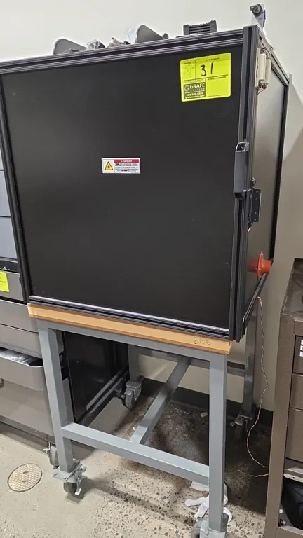Thorlabs optical breadboard enclosure cabinet. Features aluminum extrusion construction, laser safety warning label, and internal Thorlabs optical bre