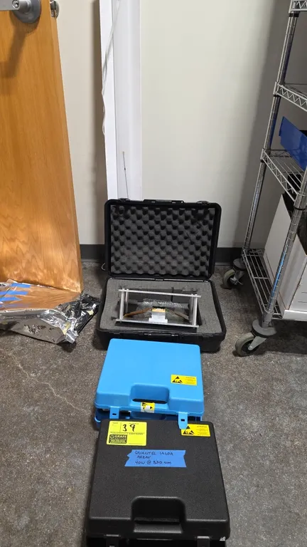 Package lot of metal frame stands with laser diode/sensor array, hard carrying cases, and shop light. Includes Quantel IALDA array marked 40W @ 830 nm
