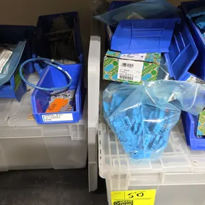 Package lot of storage containers and components. Includes (2) plastic attached-lid totes, blue stacking parts bins, and assorted electrical component