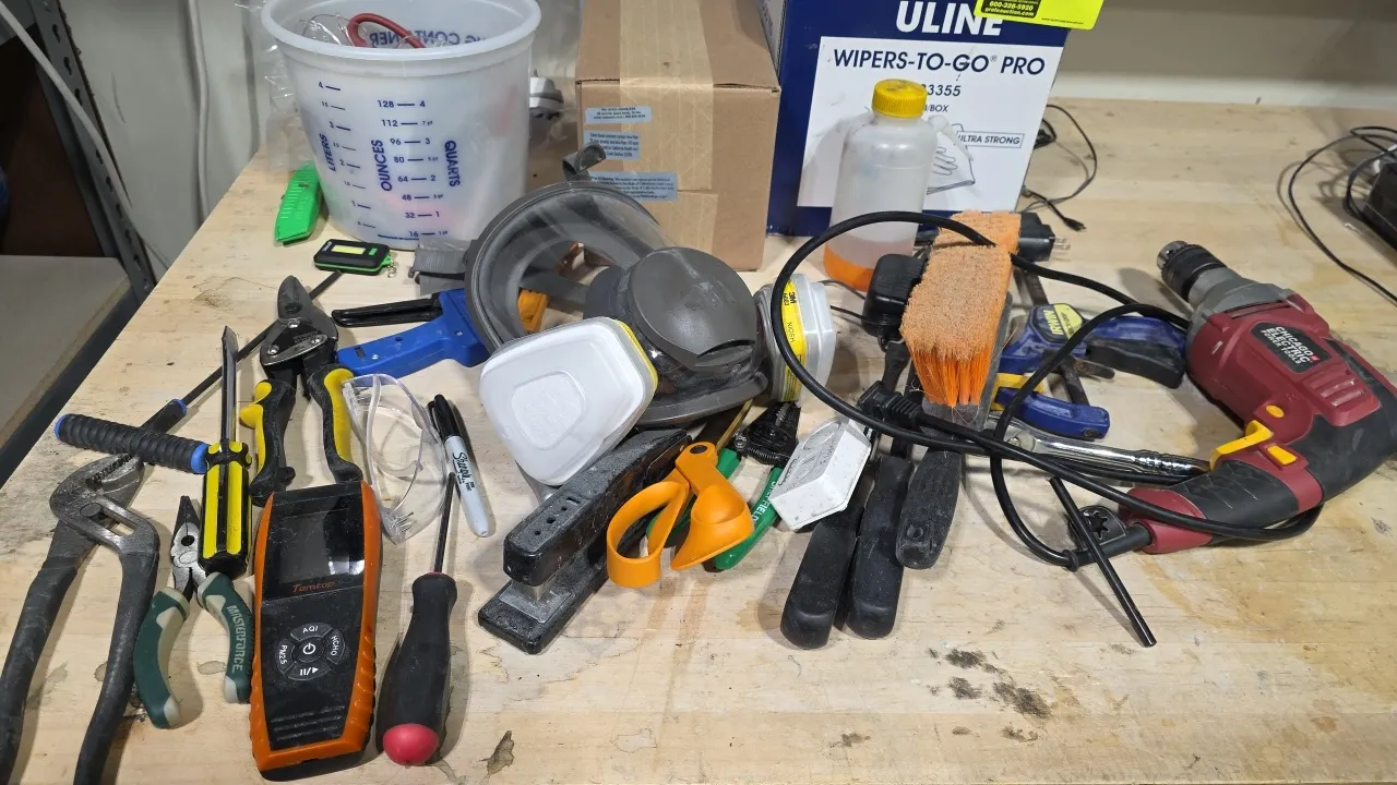 Assorted hand tools, corded drill, and shop supplies. Includes Chicago Electric corded drill, 3M respirator mask with filters, Temtop handheld air qua