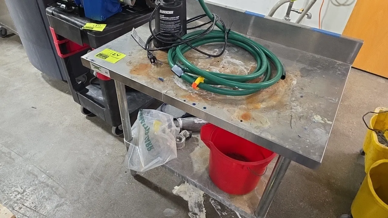 Regency 36" x 24" stainless steel work table with undershelf. Features a rear backsplash and adjustable bullet feet. Lot includes a Barracuda 1/4 HP s