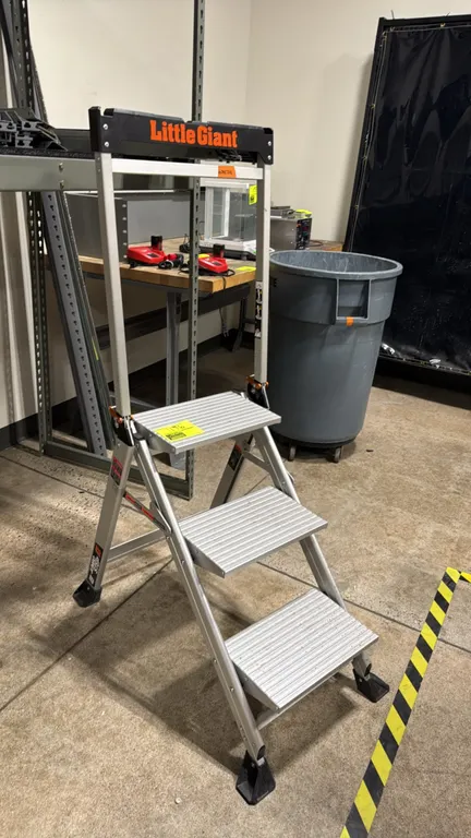 Little Giant Jumbo Step 3-step aluminum step ladder. Features slip-resistant treads, folding safety handrail with integrated tool tray, and wide rubbe