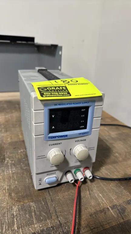 Tekpower TP3005T DC regulated power supply. Features digital voltage and current display, coarse and fine adjustment controls, top carrying handle, an