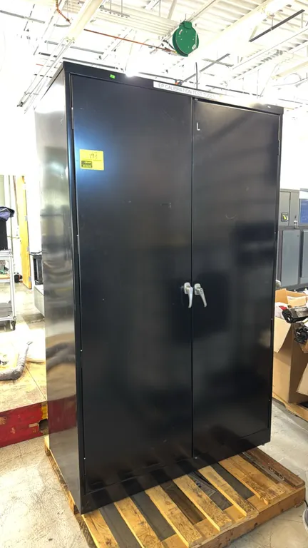 Metal 2-door storage cabinet. Features dual front latch handles, black finish, and adjustable interior shelving. Dimensions: 4' x 2' x 6 1/2'. Content