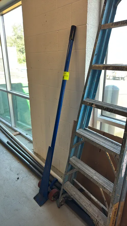 Steel wheeled lever pry bar (J-bar). Features a tubular steel handle with vinyl grip, beveled steel nose plate, and dual polyurethane wheels. Ladder a