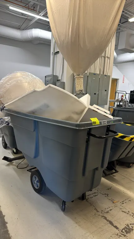 Uline H-4184GR utility tilt truck. Features gray polyethylene construction, 1 cu yd capacity, and integrated steel push handle. Mounted on two main wh